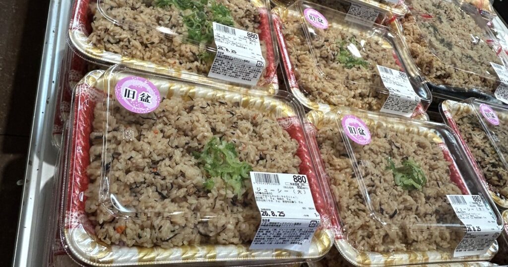 旧盆のシールが貼られたジューシーのパックが並ぶ売り場