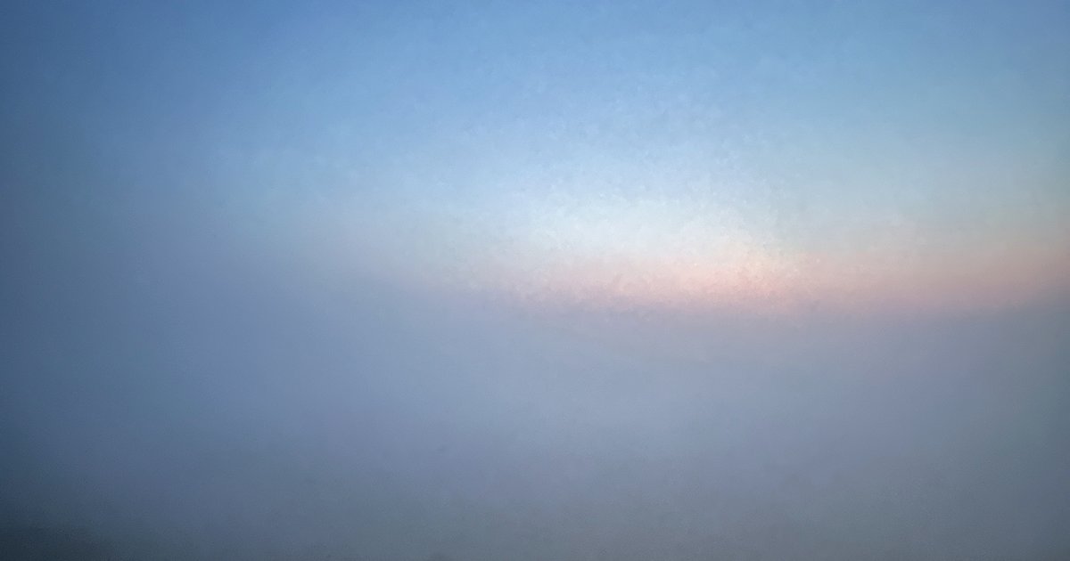 靄がかかった夜明けの空と海